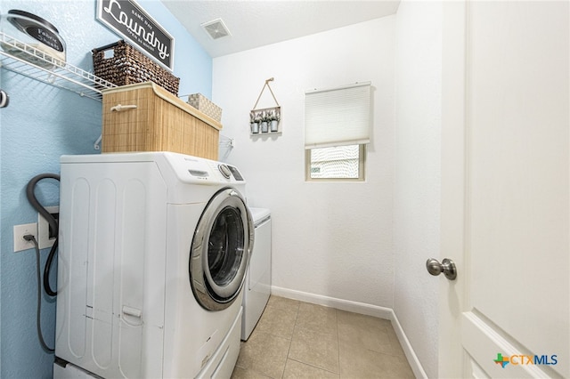 4431 Hogg, San Antonio, TX 78223 - laundry area with washing machine and clothes dryer and light tile patterned floors