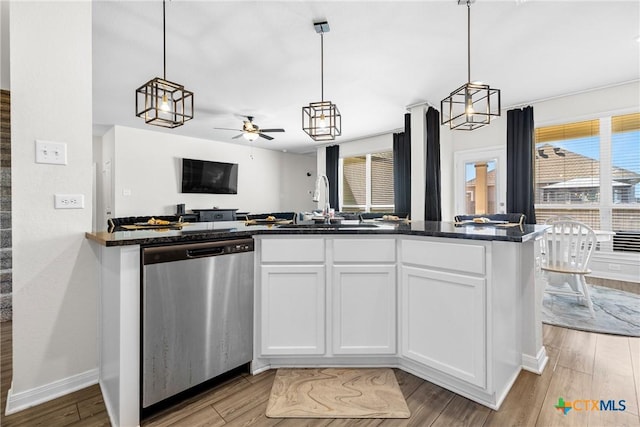 kitchen featuring a sink, stainless steel dishwasher, open floor plan, white cabinetry, and light wood finished floors