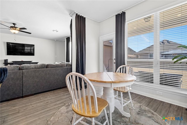 dining room featuring baseboards, wood finished floors, visible vents, and ceiling fan