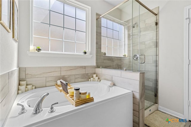 bathroom featuring a shower stall and a garden tub