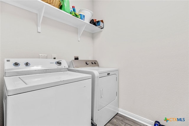 laundry area featuring laundry area, light wood-type flooring, baseboards, and separate washer and dryer