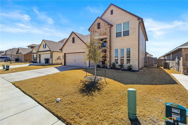 traditional-style home with brick siding, fence, central AC, stone siding, and driveway