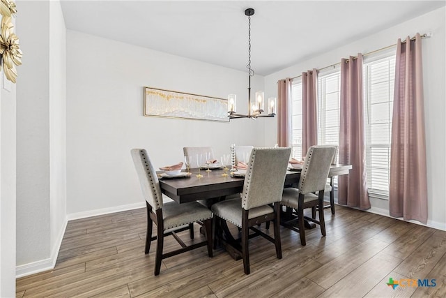 dining area with an inviting chandelier, baseboards, and wood finished floors