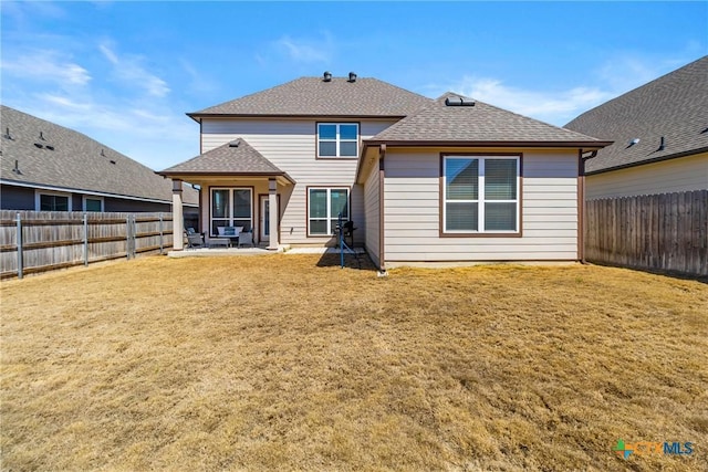 rear view of property with a lawn, a fenced backyard, and roof with shingles