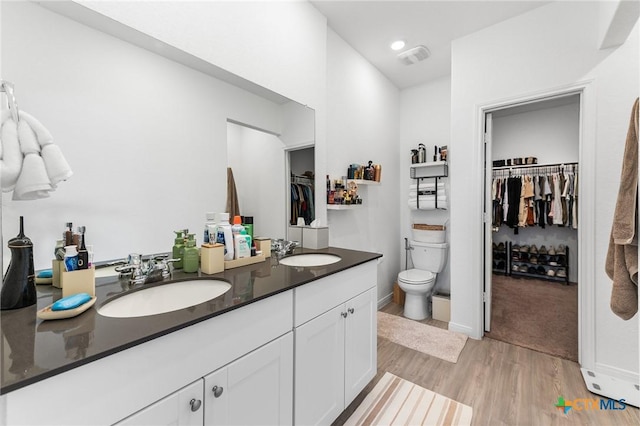 5903 Geronimo Vis, Seguin, TX 78155 - full bath with double vanity, toilet, wood finished floors, a walk in closet, and recessed lighting