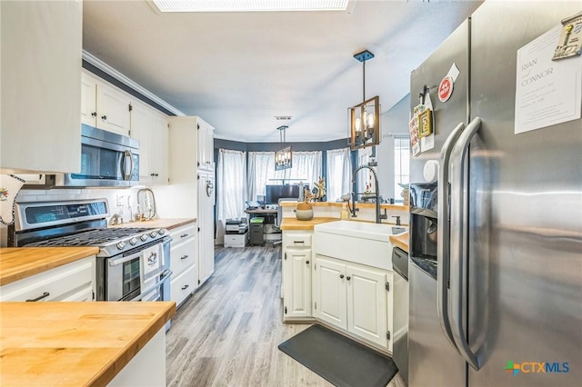 1811 Rally Ln, Harker Heights, TX 76548 - kitchen with appliances with stainless steel finishes, wood counters, white cabinets, pendant lighting, and light wood-style flooring