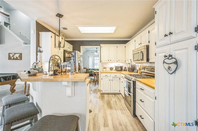 1811 Rally Ln, Harker Heights, TX 76548 - kitchen featuring stainless steel appliances, light wood-style flooring, butcher block countertops, white cabinets, and a breakfast bar