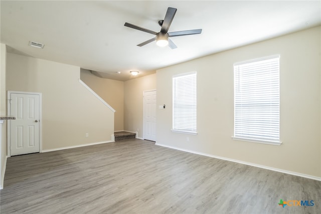 spare room featuring light wood-type flooring, a wealth of natural light, and ceiling fan