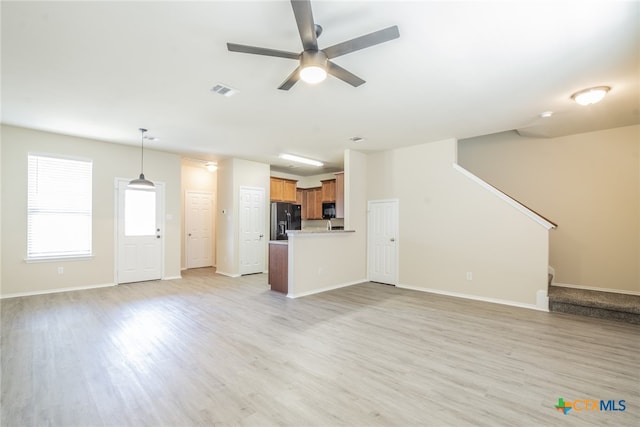 unfurnished living room with ceiling fan and light wood-type flooring