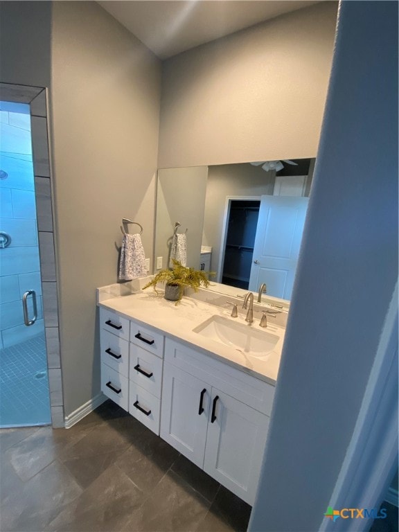 bathroom featuring tile patterned flooring, an enclosed shower, and vanity