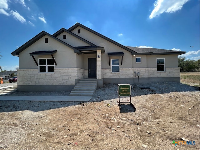 view of front of home featuring stone siding and stucco siding