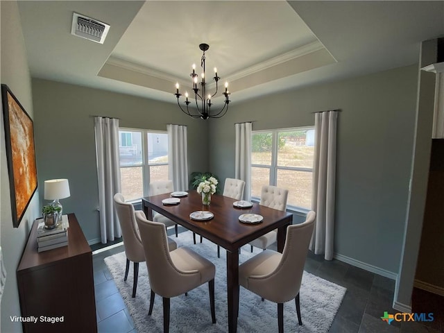 dining room featuring an inviting chandelier, visible vents, a tray ceiling, and a wealth of natural light