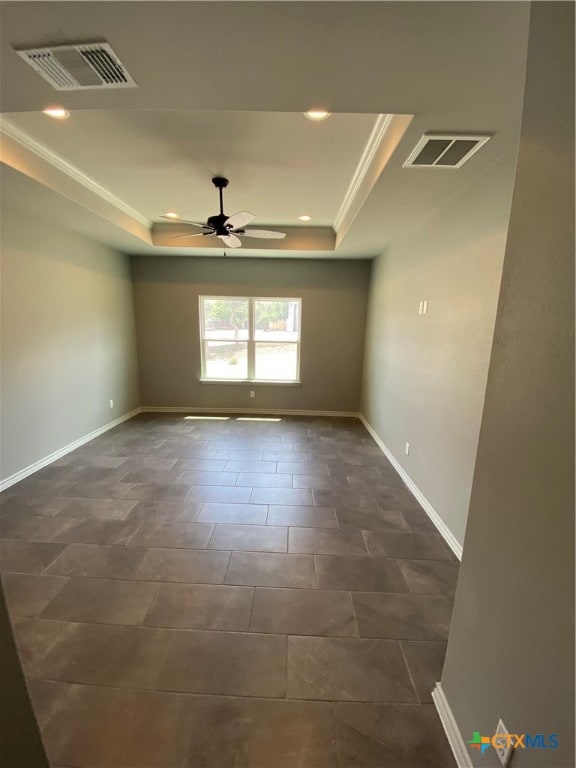 empty room featuring ceiling fan, ornamental molding, and a tray ceiling