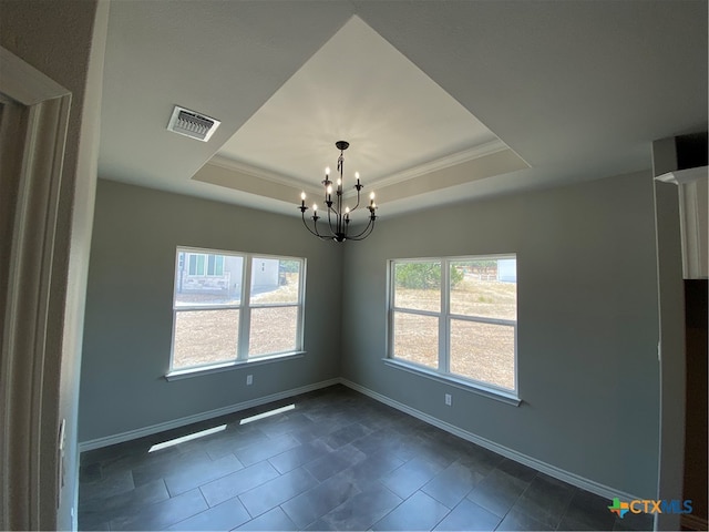 tiled empty room featuring a chandelier, crown molding, and a raised ceiling