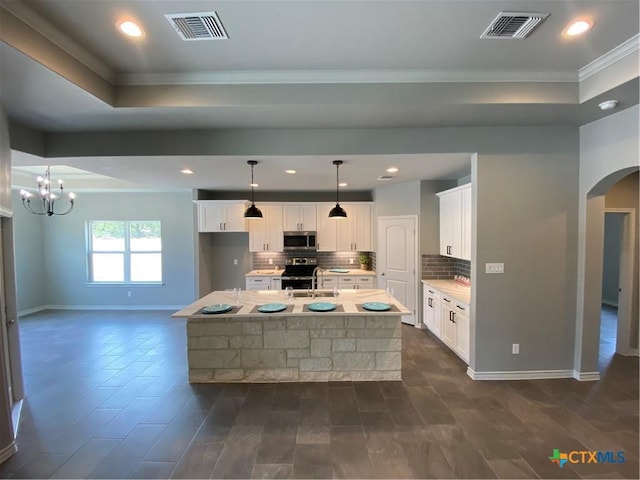120 S Calvin Barrett, Blanco, TX 78606 - kitchen with appliances with stainless steel finishes, ornamental molding, backsplash, arched walkways, and light countertops