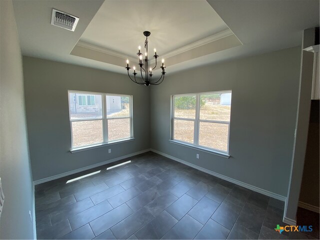 tiled spare room with a raised ceiling, an inviting chandelier, and ornamental molding