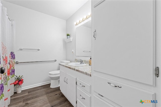296 Valiant Wills Rd, Bruceville-Eddy, TX 76630 - full bathroom featuring wood finished floors, vanity, toilet, and baseboards