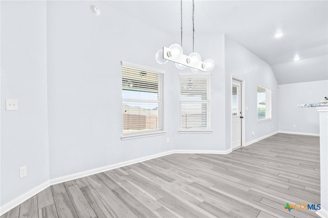 unfurnished dining area featuring light hardwood / wood-style floors and vaulted ceiling