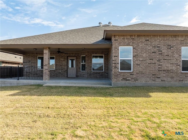 rear view of house featuring a lawn and a patio