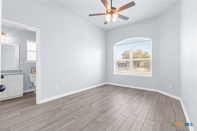 empty room with ceiling fan and light hardwood / wood-style floors