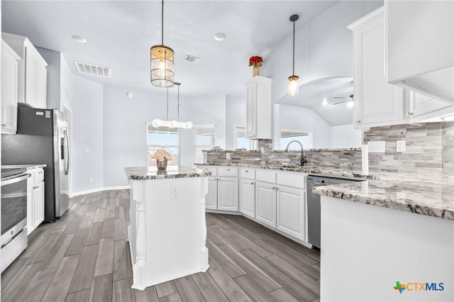 kitchen with white cabinetry, ceiling fan, light stone countertops, wood-type flooring, and a kitchen island