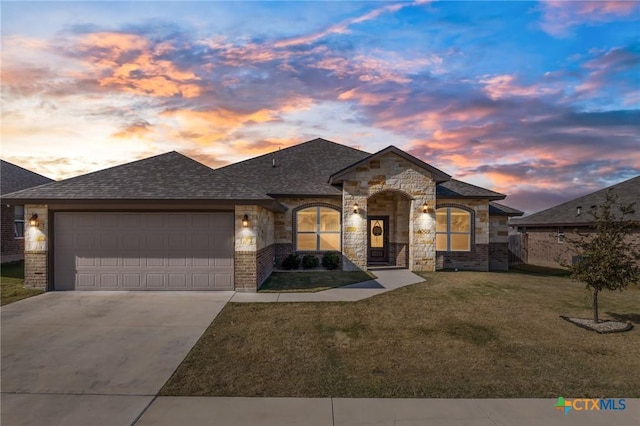 french country style house featuring a garage and a yard