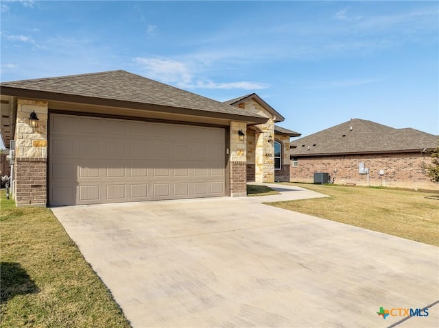 view of front of property with cooling unit, a garage, and a front lawn