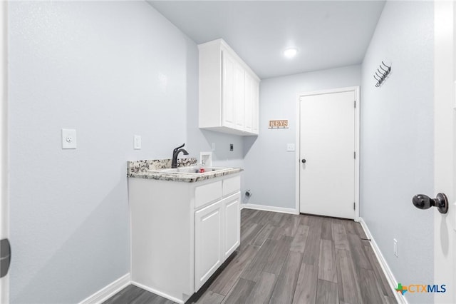 laundry area with sink, cabinets, washer hookup, hookup for an electric dryer, and hardwood / wood-style flooring