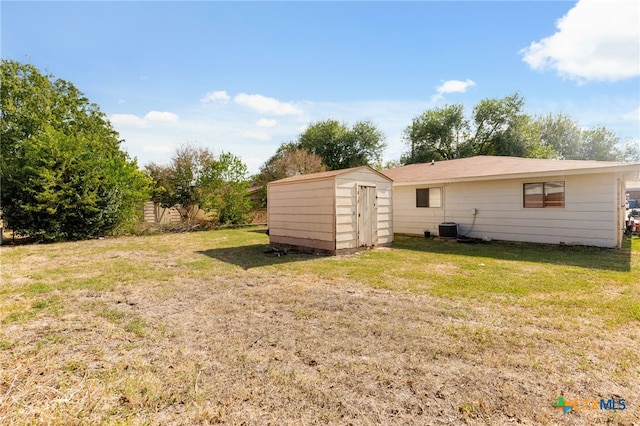 view of yard featuring central AC and a shed