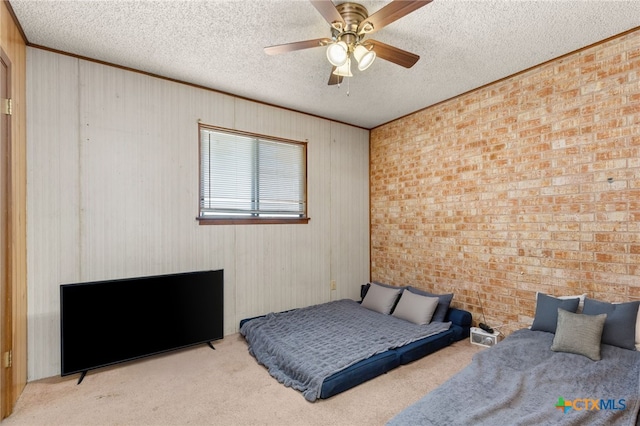 bedroom with ceiling fan, brick wall, light colored carpet, a textured ceiling, and wooden walls