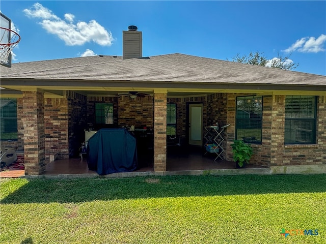 back of house featuring a lawn and ceiling fan