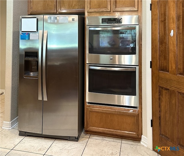 kitchen with light tile patterned flooring and appliances with stainless steel finishes