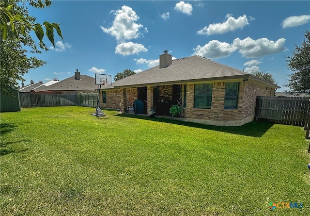 rear view of property with a yard