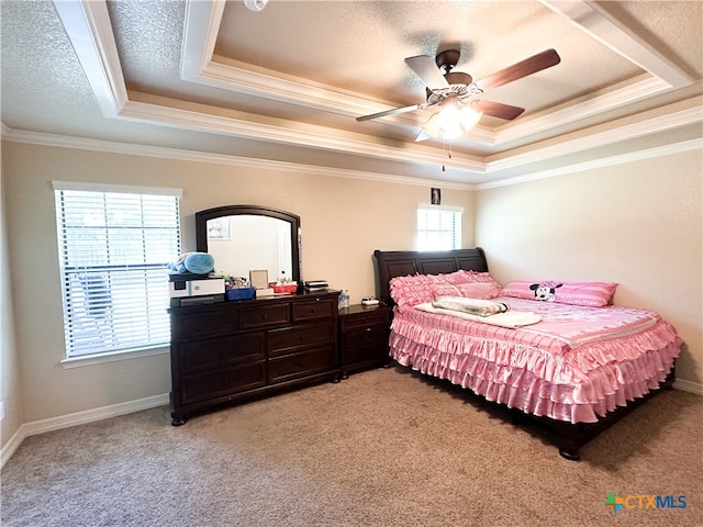 bedroom with light carpet, a tray ceiling, ceiling fan, and crown molding