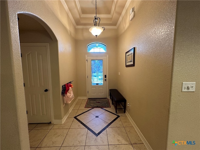 doorway to outside featuring a raised ceiling, light tile patterned floors, and ornamental molding