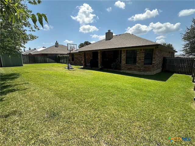 rear view of house featuring a lawn