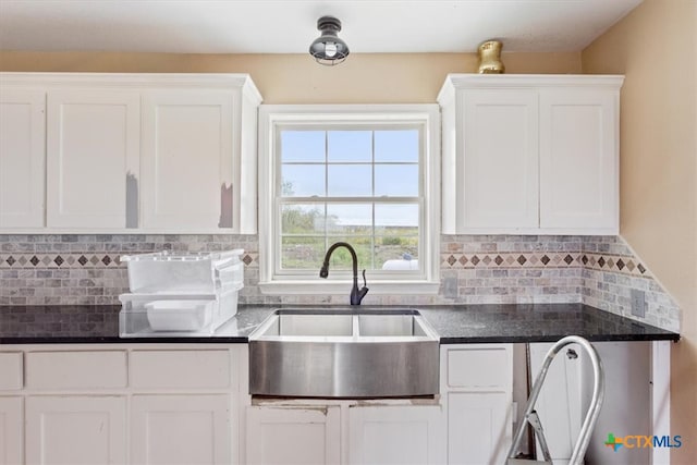 kitchen featuring decorative backsplash, sink, and white cabinets