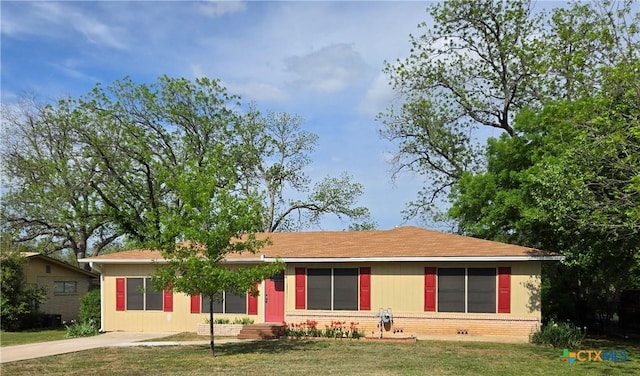 single story home with concrete driveway, brick siding, and a front lawn