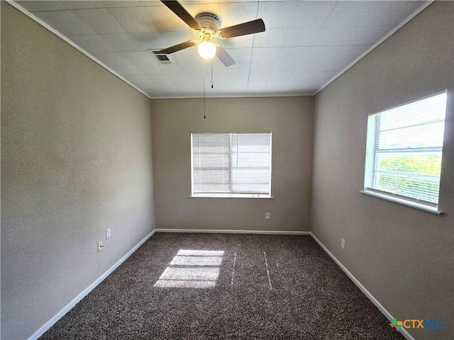 carpeted empty room featuring visible vents, a ceiling fan, baseboards, and ornamental molding