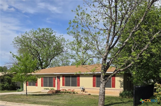 ranch-style house featuring brick siding and a front lawn