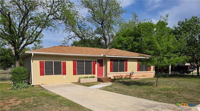 view of front of home with a front lawn, driveway, and fence