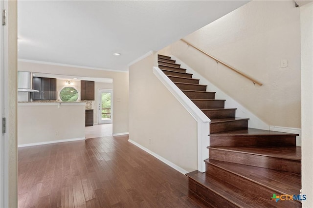 stairs featuring crown molding and hardwood / wood-style flooring