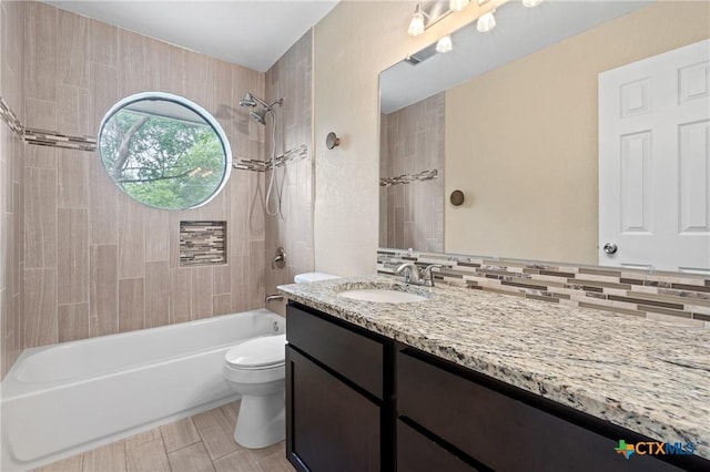 full bathroom featuring vanity, backsplash, toilet, and tiled shower / bath