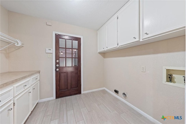 clothes washing area featuring cabinets, washer hookup, and light wood-type flooring