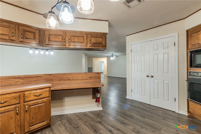 kitchen with ceiling fan with notable chandelier, dark wood-type flooring, black appliances, wood counters, and built in desk