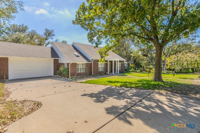 ranch-style home featuring a garage and a front yard