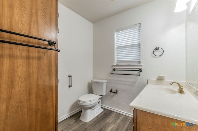 bathroom with vanity, hardwood / wood-style flooring, and toilet