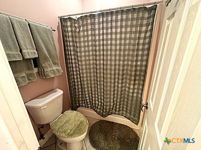 bathroom featuring tile patterned flooring, toilet, and walk in shower