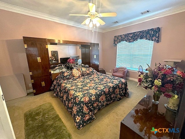 carpeted bedroom featuring ceiling fan and ornamental molding