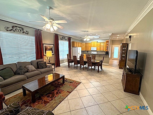 tiled living room featuring ceiling fan and crown molding